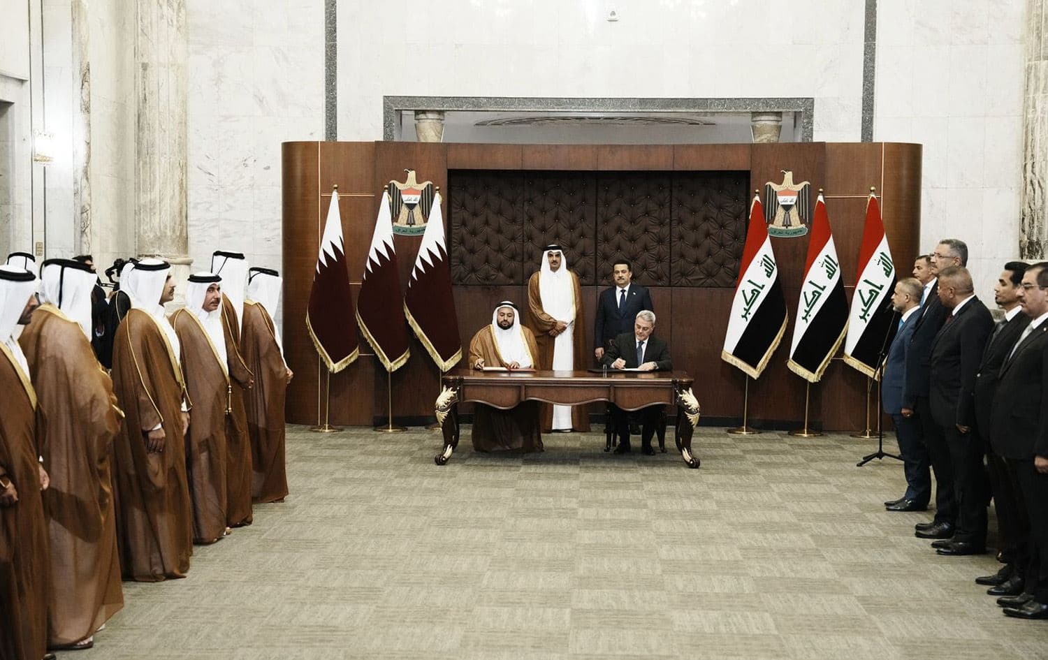 A handout picture released by Iraq's Prime Minister's Media Office shows Prime Minister Mohamed Shia al-Sudani (R) and Qatari Emir Sheikh Tamim bin Hamad al-Thani (L) standing during the signing of deals between the two countries at the PM's office in Baghdad's Green Zone on June 15, 2023. Photo: PM Sudani's office