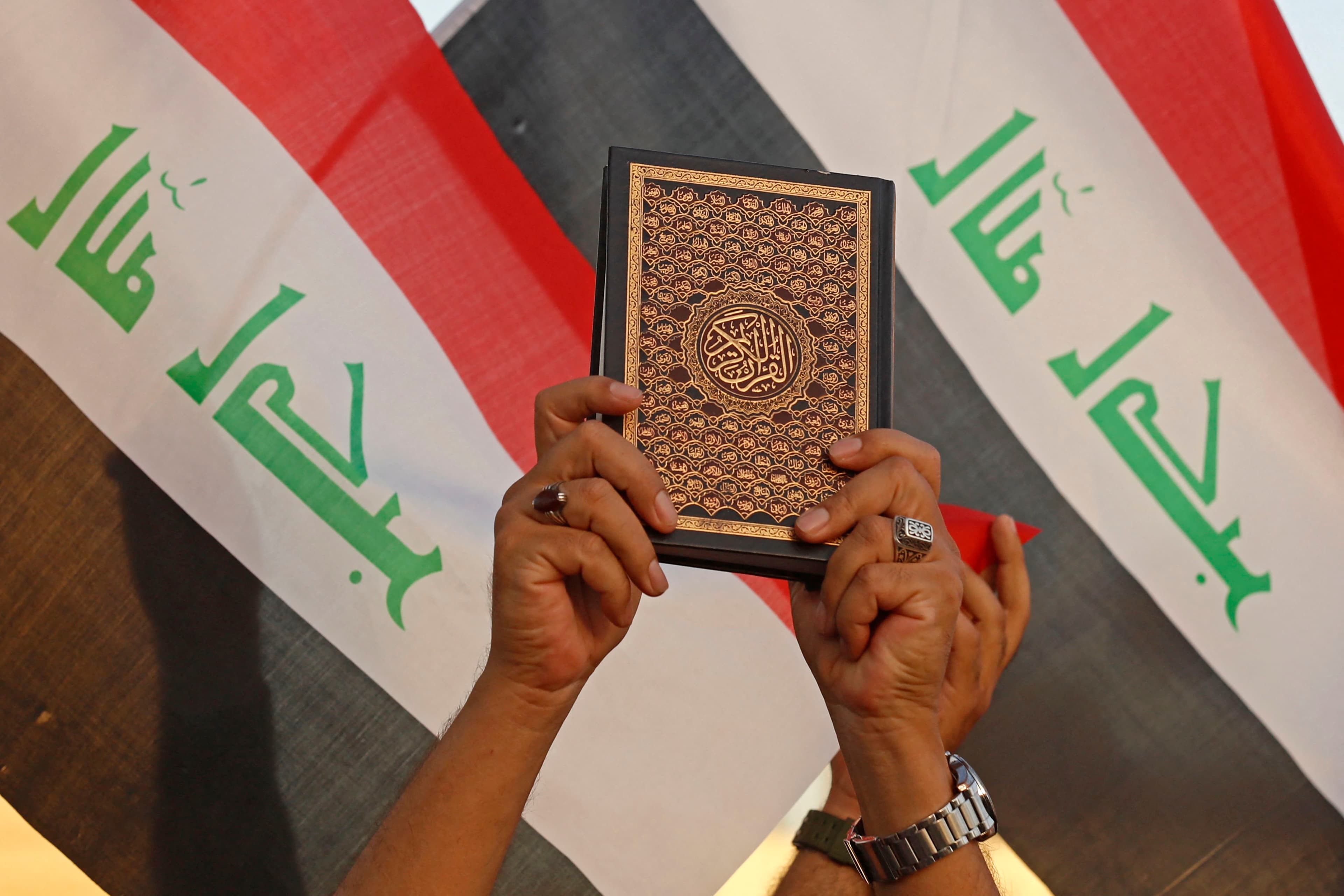 An Iraqi man holds the Koran during a protest in Baghdad's Tahrir Square on July 20, 2023. Photo: AFP 