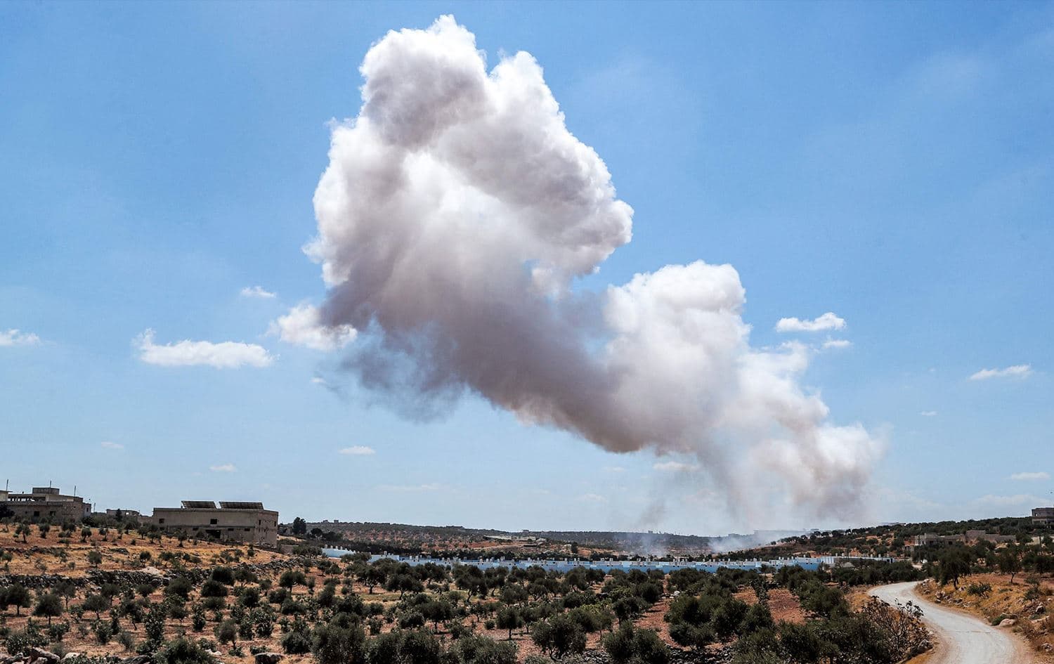 A smoke plume rises after an aerial bombardment near a make-shift camp for displaced Syrians near the town of Kafraya, north of Syria's Idlib province, on September 7, 2021. Photo: AFP