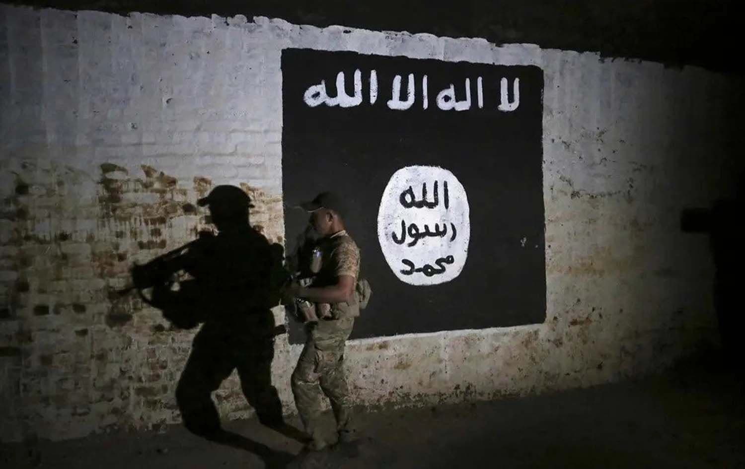 An Iraqi soldier inspects a recently-discovered train tunnel, adorned with an ISIS group flag. File photo: AP