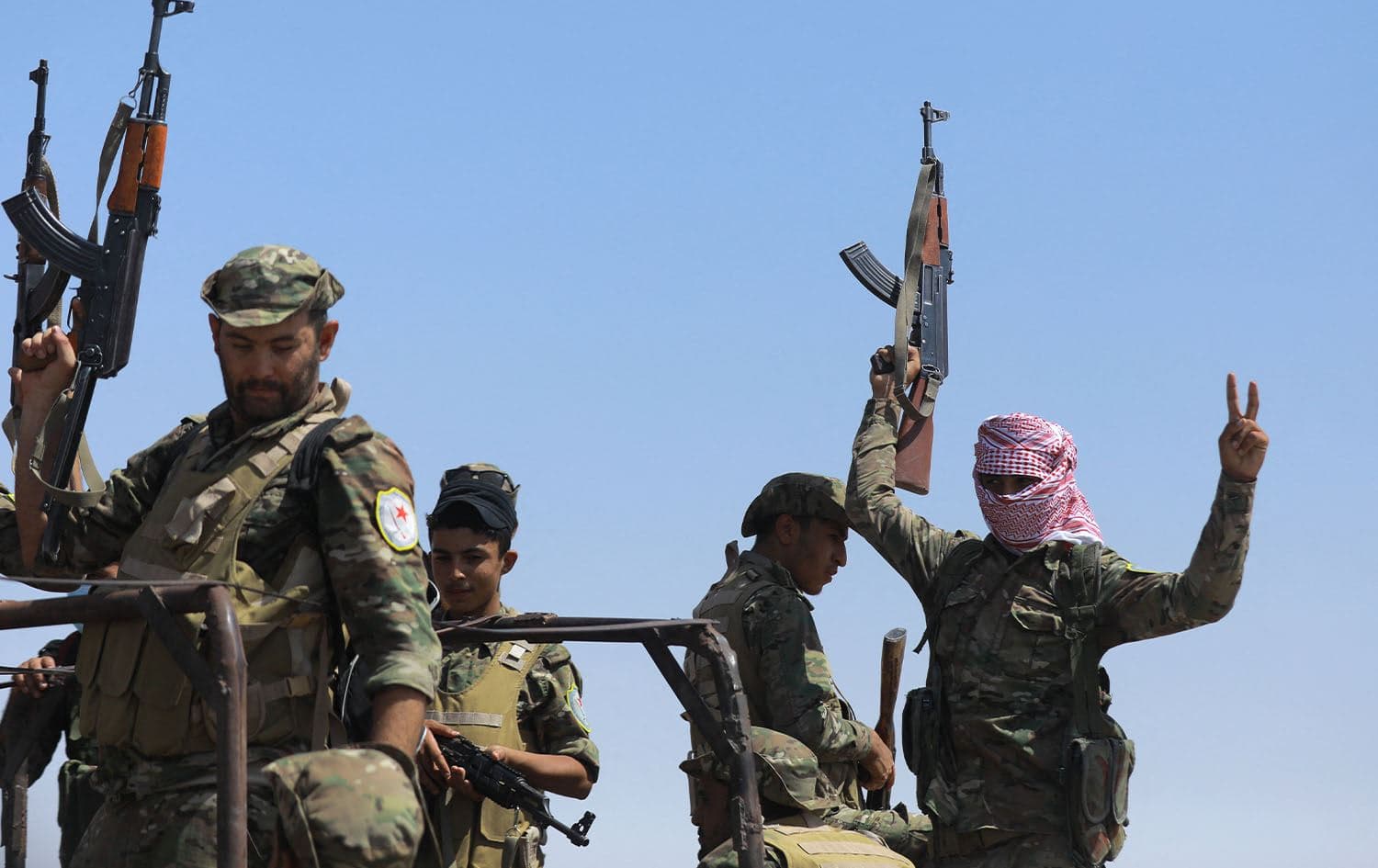 Fighters of the Syrian Democratic Forces (SDF) gesture as they move to the Dhiban front line in the Deir Ezzor province in eastern Syria on September 4, 2023. Photo: Delil Souleiman/AFP