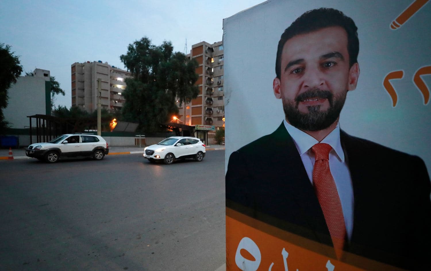 Vehicles drive past a billboard showing ousted Iraqi Parliament Speaker Mohamed al-Halbussi, who is running in the local elections in December, along a main road in Baghdad on November 14, 2023. Photo: Ahmad al-Rubaye/AFP