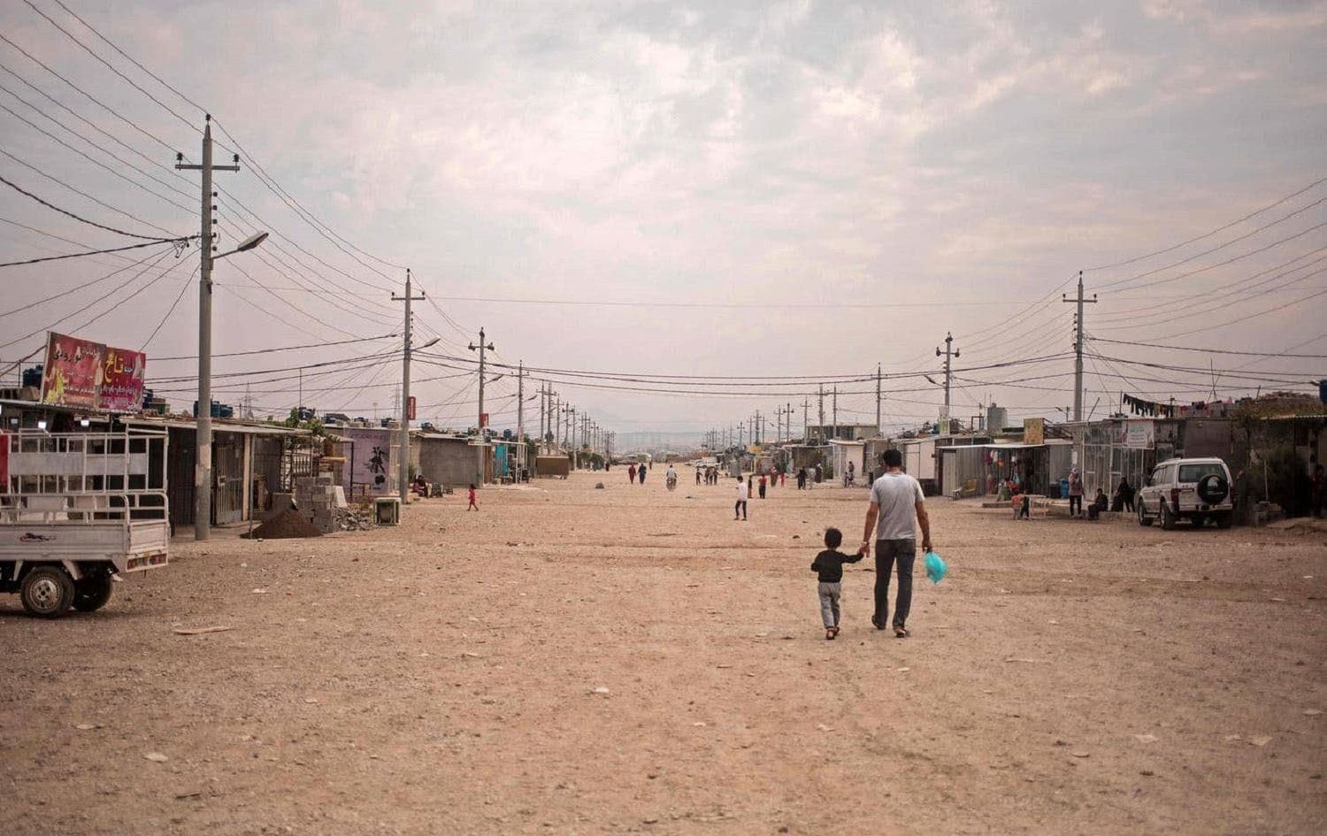 A father and his daughter walk together in the Arbat camp in Sulaimani province on November 3, 2020. Photo: AFP