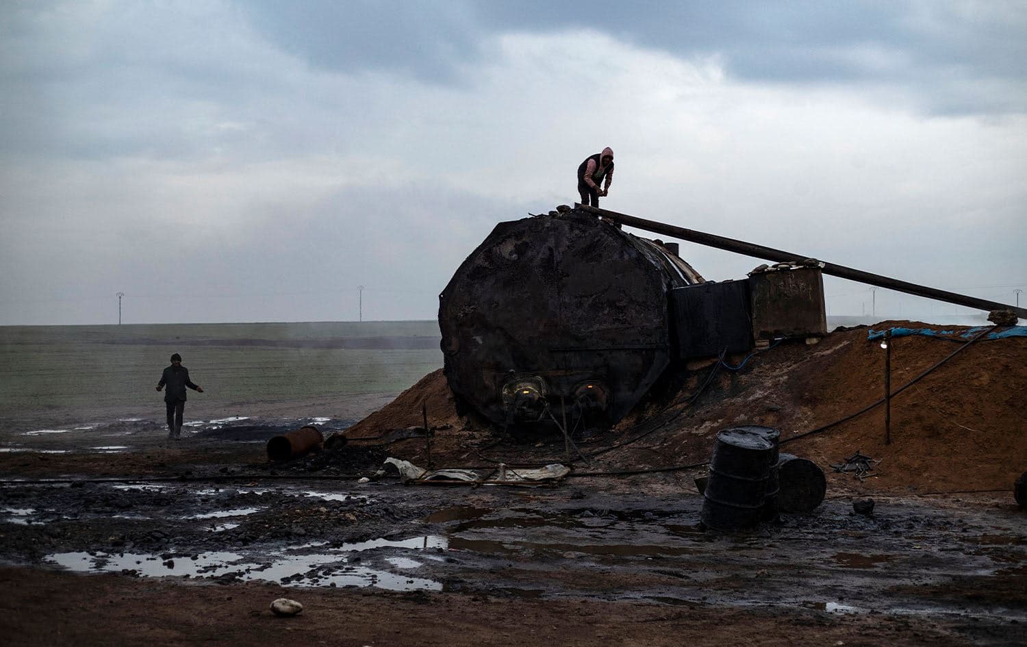 A picture taken on January 11, 2024, shows people working at a primitive oil facility in the Abu Ghadir area in Qamishli. Photo: Delil Souleiman/AFP