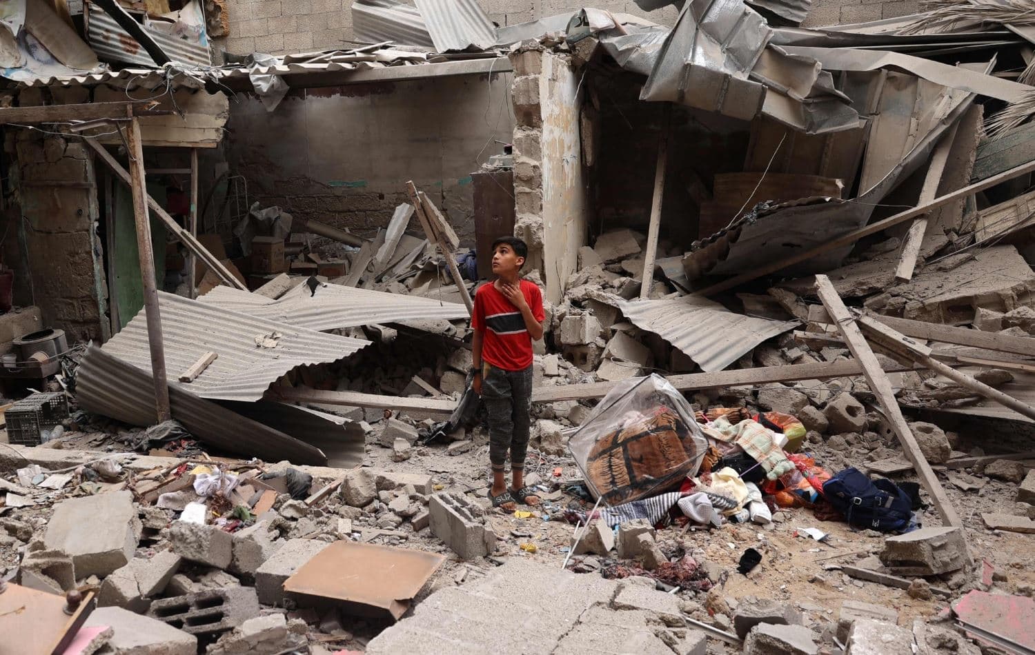  منداڵێک لەنێو داروپەردووی بینایەکی رووخاو لە رەفەح، وێنە: AFP