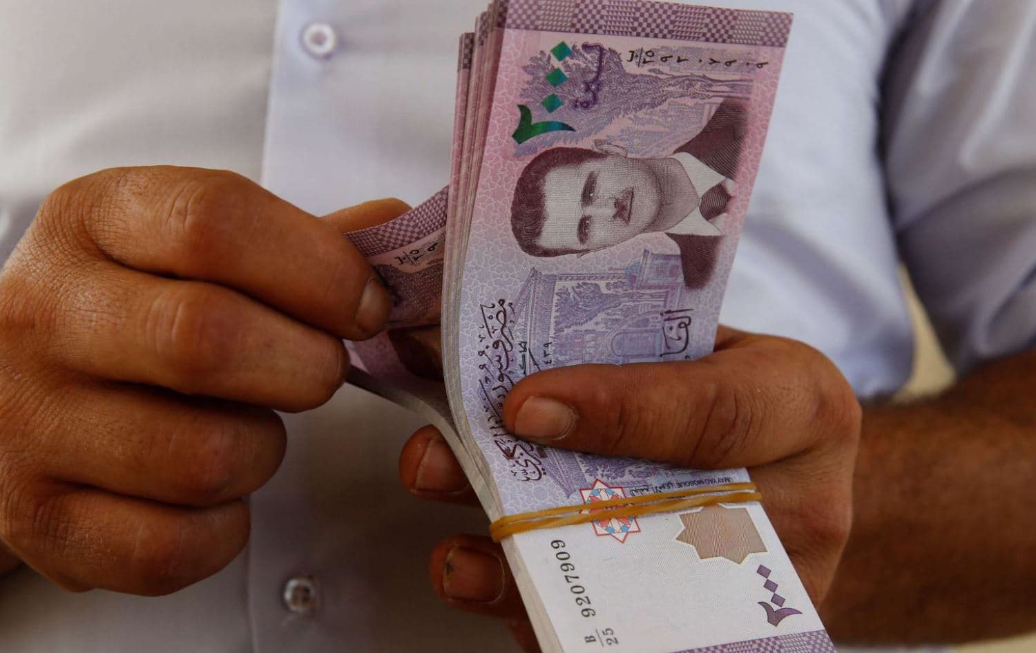 لیرەی سووری بەدەست پیاوێکەوە