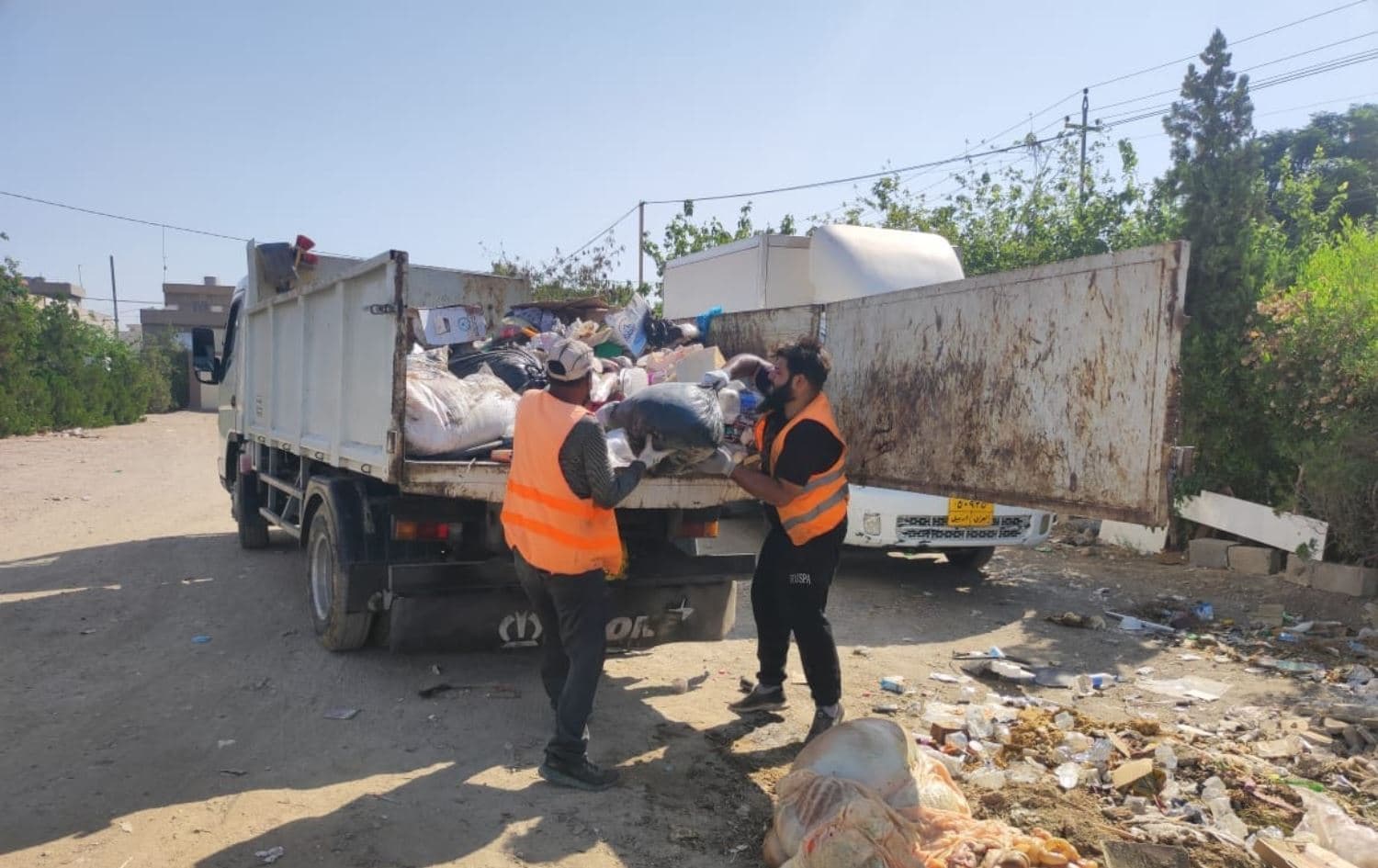تیمێکی شارەوانی لەکاتی هەڵگرتنەوە و پاککردنەوەی پاشماوەی ئاژەڵی قوربانی. وێنە: ئەرشیڤ