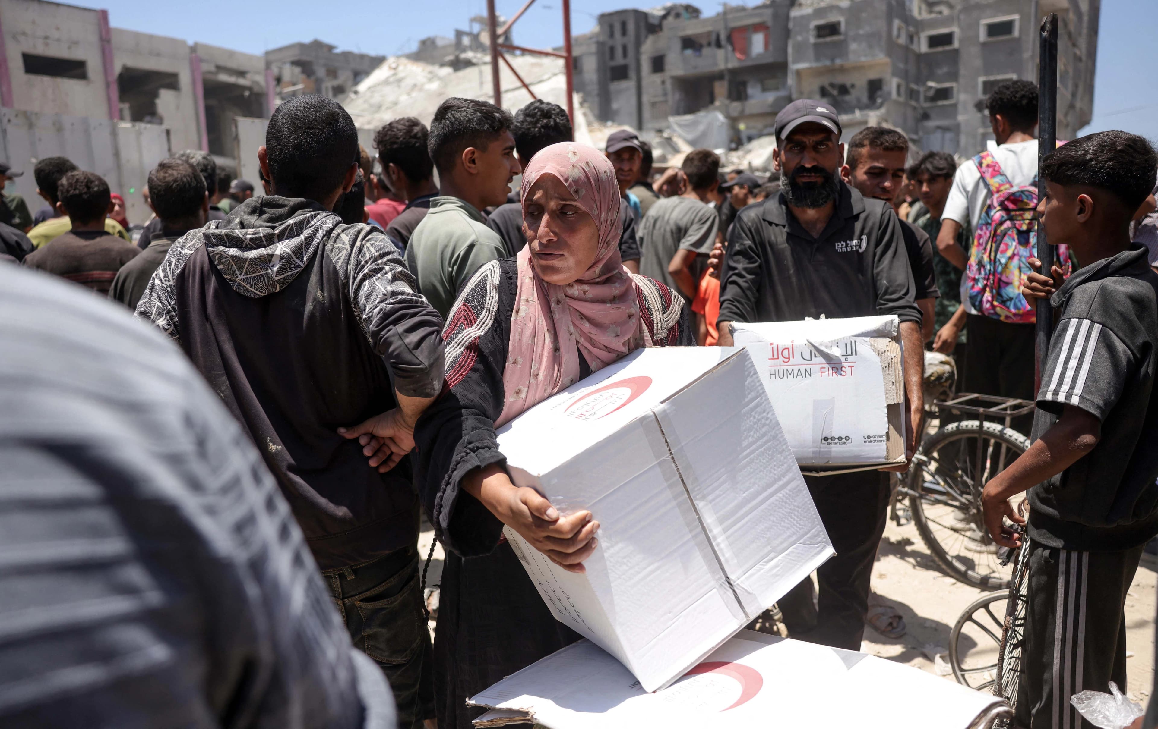 غەززەییەکان لەکاتی وەرگرتنی هاوکاری کە مانگی سووری ئیماراتی نۆی ناردوون لە رۆژی 26-6-2025: AFP