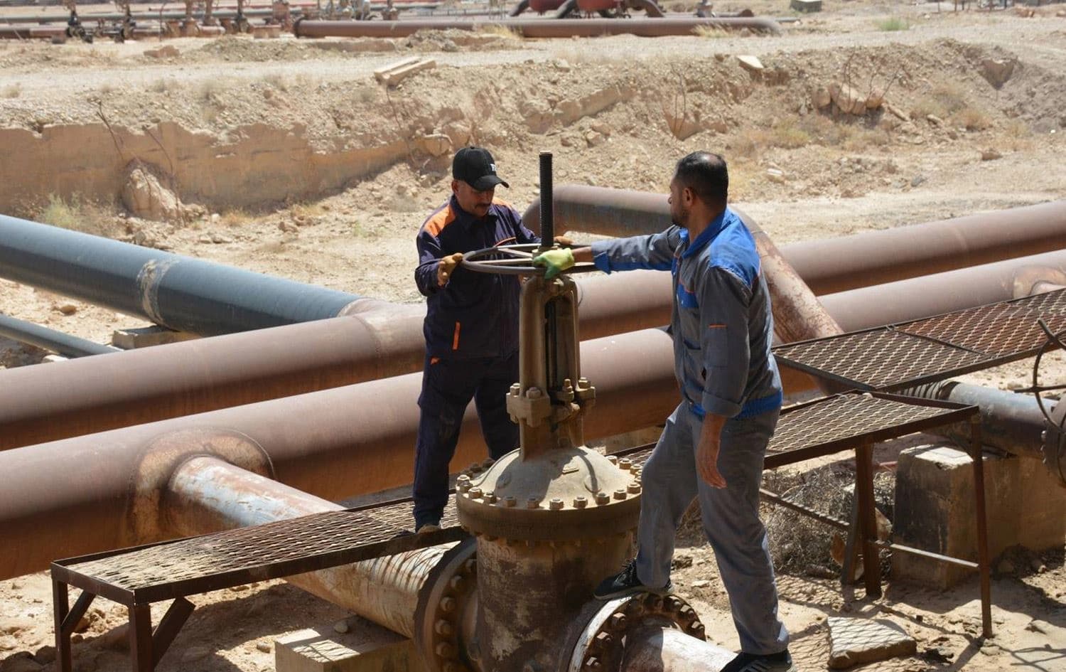 دوو کارمەندی کۆمپانیای نەوتی باکوور لەکاتی کارکردن لە کێڵگەیەکی نەوتی لە کەرکووک. وێنە: کۆمپانیای نەوتی باکوور