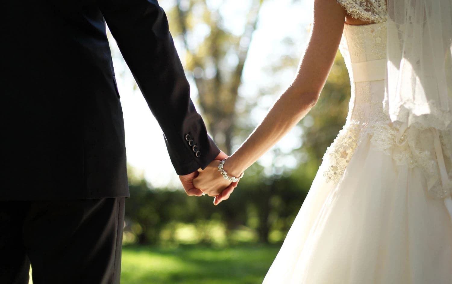 دوو کەس لە رۆژی هاوسەرگیری دەستی یەکدییان گرتووە