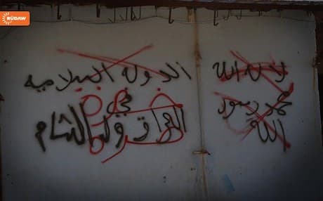 ISIS graffiti crossed out by Kurdish forces in Shingal