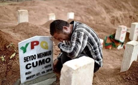 AFP file photo of a mourner in Rojava at the grave of a dead YPG fighter. 