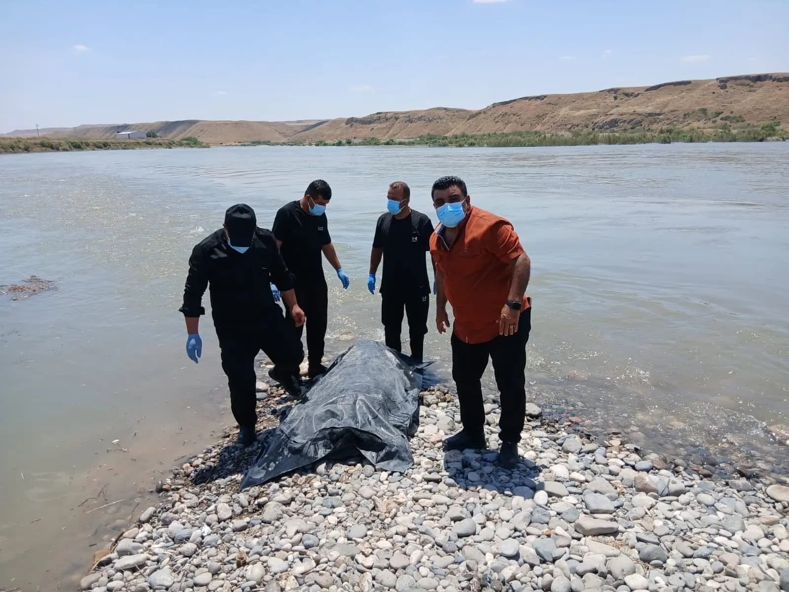 دەرهێنانی تەرمی کەسێک کە لە ئاوێکی سنووری زاخۆ خنکاوە. وێنە: بەرگریی شارستانی