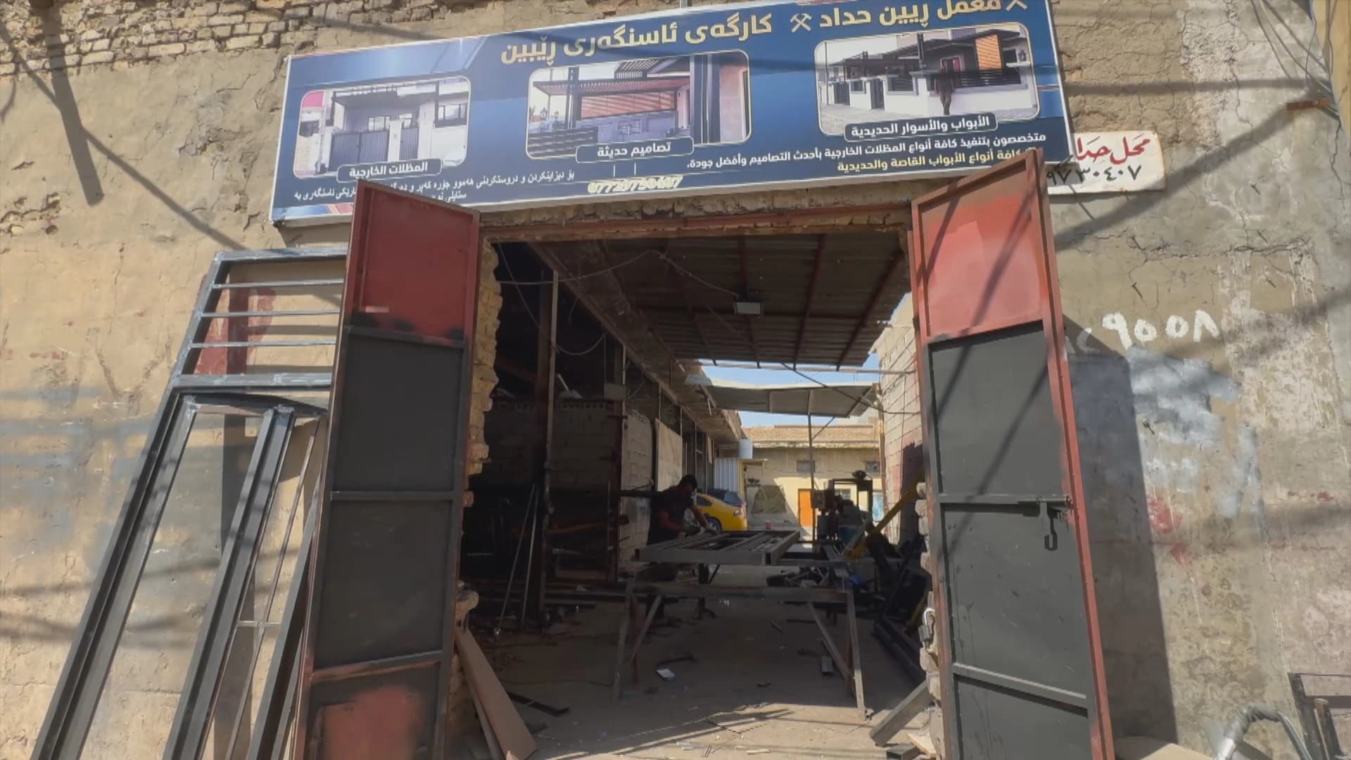Man arrested in disputed region for adding Kurdish to shop sign, family says