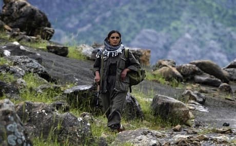 A PKK female guerrilla walking in the foothills of the Qandil Mountains. Photo: AFP