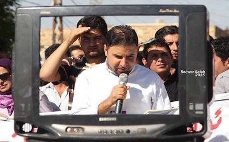 A Halabja teacher delivers a speech to fellow protesters through a broken TV set that "has no logo or color" as a symbol of their impartiality in party politics. Photo by Rebwar Salah