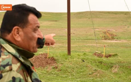 A Kakai Peshmerga commander points to a mined field that was marked by an Italian organization for removal between Erbil and Mosul. Photo: Rudaw