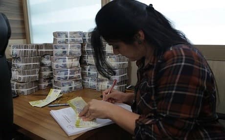 A bank worker in Kurdistan Region. Kurdish Region does not have a strong banking system which may make the tax collection difficlut to be applied. Photo: Rudaw