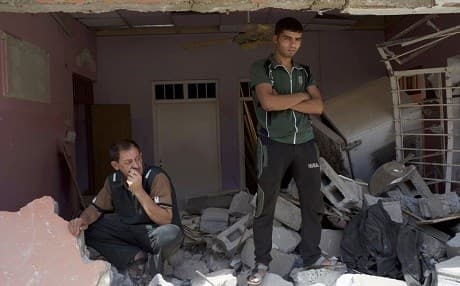 Manhal Samir and Abdulrahman Mohammed, two neighbors, look at the ruins of a house in western Mosul on Friday, May 26, 2017, destroyed in a March 17 coalition airstrike that killed more than 100 people. A coalition investigation released on Thursday asserted that the strike had targeted two Islamic State snipers and the destruction had been caused by a large amount of explosives IS militants had placed in the building, a claim disputed by survivors and neighbors. Photo: AP/Balint Szlanko