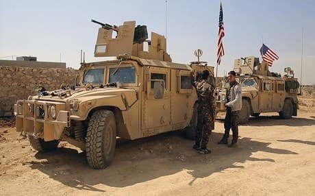 Members of the mainly-Kurdish Syrian Democratic Forces stand near US military vehicles in March 2017 in the Syrian town of Manbij as tensions between the SDF and Turkish-backed forces escalated. File photo: AP/Arab 24 Network