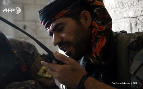 A member of the YPG communicates through a radio in Raqqa on July 21, 2017. Photo: Delil Souleman | AFP
