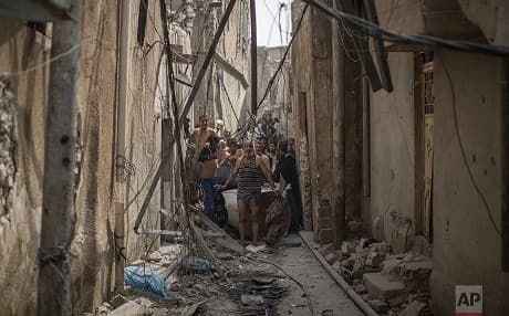 Men fleeing Mosul strip to prove to Iraqi forces they are not carrying explosives. Photo: Felipe Dana/AP