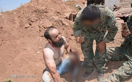 YPG forces speak with a member of the Turkish-backed Jaish al-Thuwar who they say surrendered to the YPG after an attack on Ein Daqna on Monday. Photo: YPG media office
