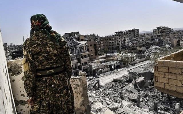 A member of the SDF looks out over western Raqqa in October. Photo: Bulent Kilic/AFP
