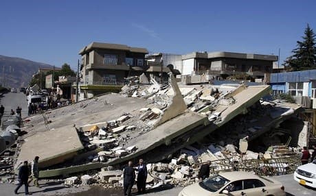 People gather around a levelled building in the mountainous town of Darbandikhan in the Kurdistan Region on November 13, 2017, following a 7.3-magnitude quake that hit the Iraq-Iran border area. File photo: AFP / Shwan Mohammed