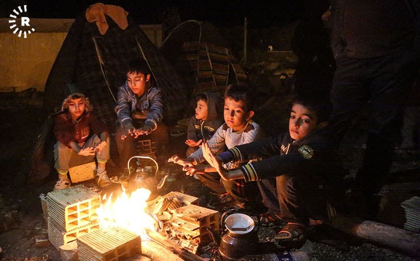 Children who lost their homes in the earthquake keep warm around a fire in Sarpol-e Zahab. Photo: Bahman Shabazi/Rudaw