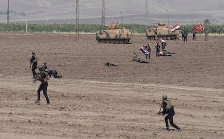 Turkish and Iraqi soldiers walk with Turkish tanks during a military drill in Silopi, near the Habur border gate with Iraq, southeastern Turkey, on Sept. 26, 2017, a day after the Kurdistan Region held a referendum on independence, a move which was strongly opposed to by Turkey and Iraq. AP photo