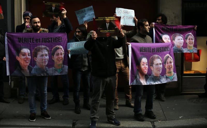 Kurds hold banners reading ‘Truth and Justice’ above the photos of Sakine Cansiz, a founder of the PKK, Fidan Dogan, and Leylay Soylemez, protesting during the visit of the Turkish president in Paris on Friday. The three women were killed in Paris five years ago. Photo: Thibault Camus/AP