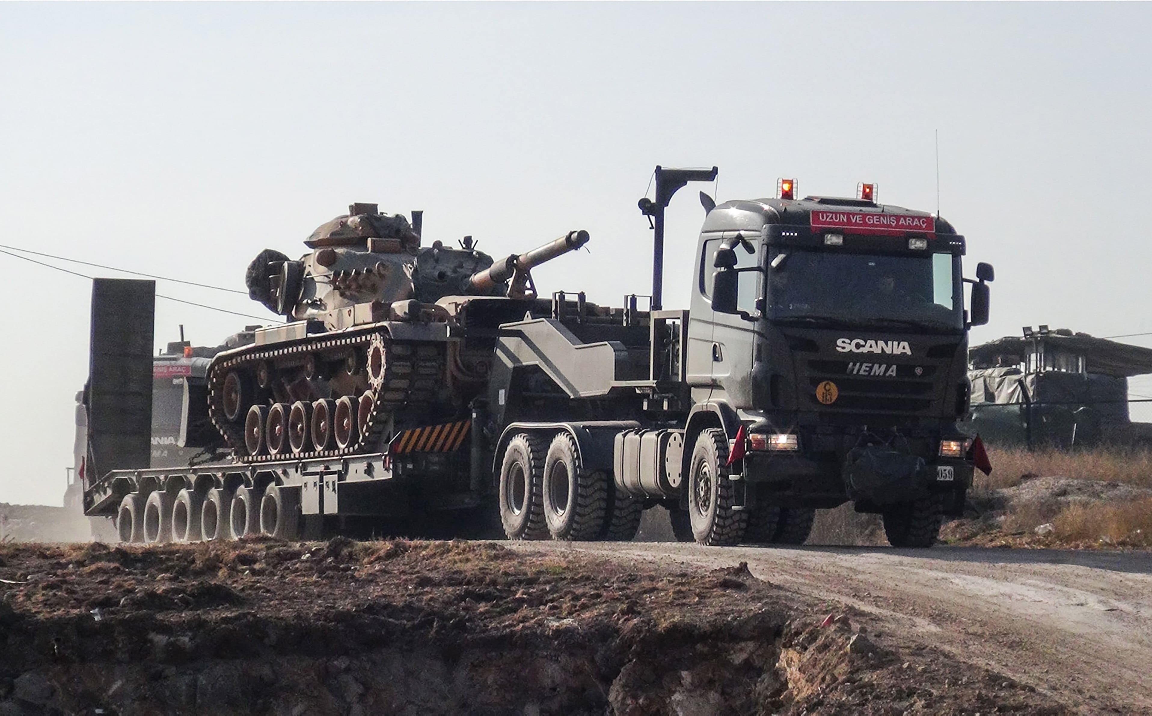 Turkish military trucks transport armoured vehiciles to reinforce units on the Syrian border in the Sanliurfa area on Tuesday. Photo: AFP/DHA