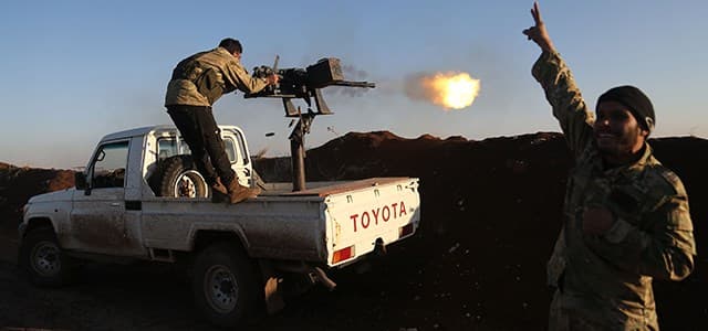 Turkish-backed fighters from the Free Syrian Army stand in the Tal Malid area, north of Aleppo, as they fire towards Kurdish People's Protection Units (YPG) positions in the village of Um al-Hosh, in the area of Afrin, on January 20, 2018. Photo: Nazeer al-Khatib | AFP