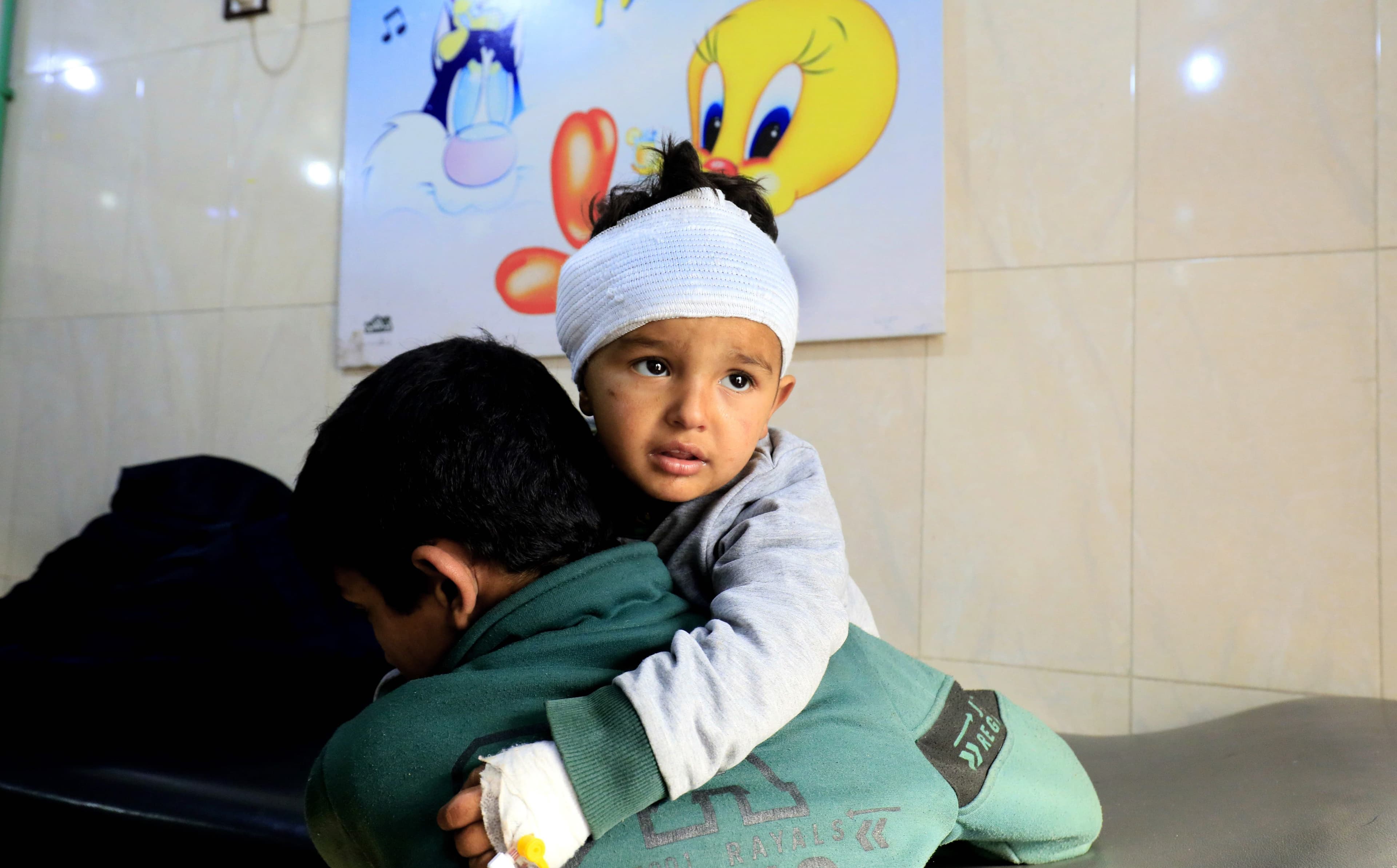 A boy injured by a Turkish airstrike is carried by his brother after receiving treatment in Afrin hospital on Tuesday. Photo: Delil Souleiman/AFP