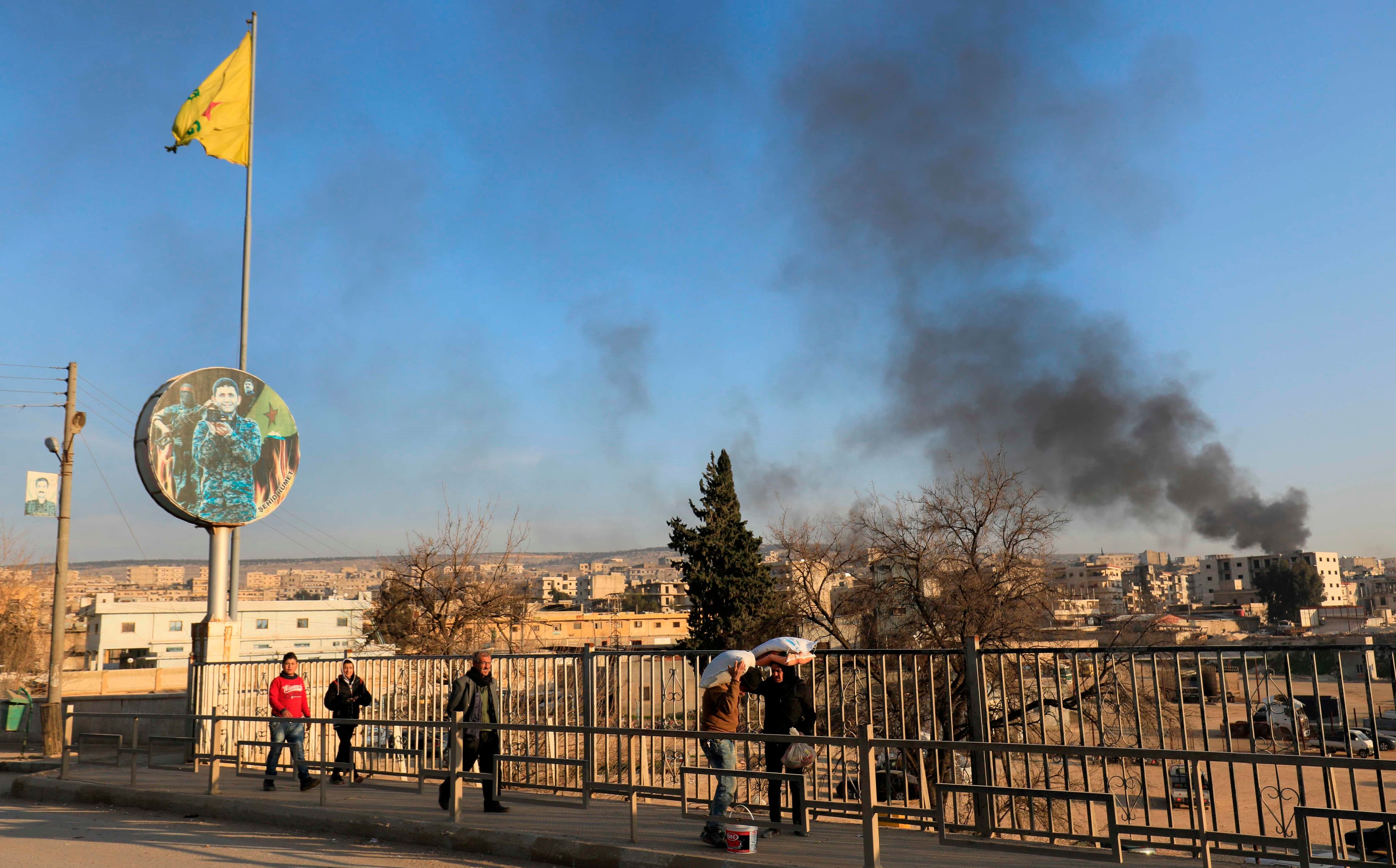 Smoke from burning tires used to block visibility of planes rises over Afrin city on Friday. Photo: Delil Souleiman/AFP