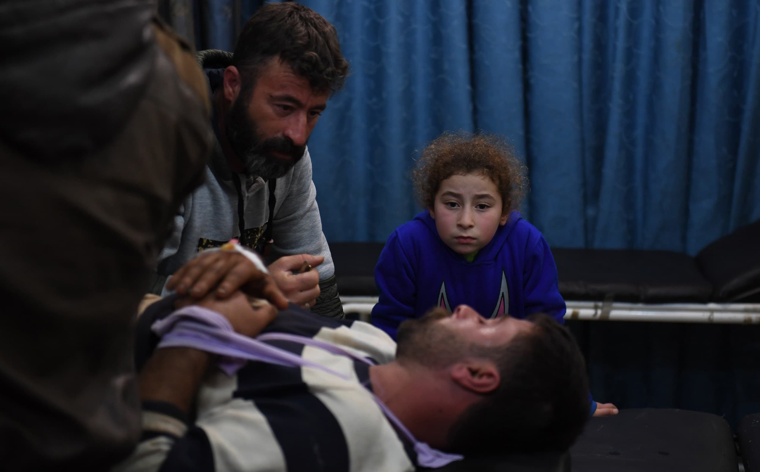 A Kurdish man rests in hospital in al-Zahraa on Thursday. He was reportedly wounded when a convoy entering Afrin came under Turkish fire. Photo: Georges Ourfalian/AFP