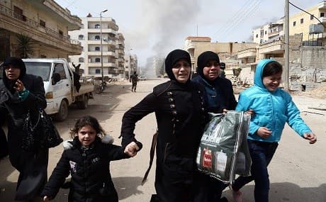 Civilians run for cover from explosions in the city of Afrin on March 18, 2018. Photo: AFP / Nazeer al-Khatib