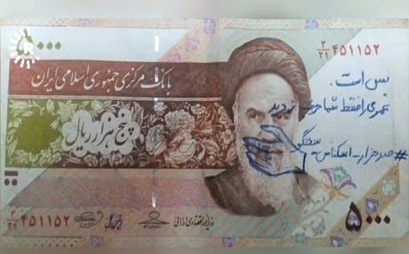 "It's enough," someone has written on an Iranian bill. Photo: Rudaw TV