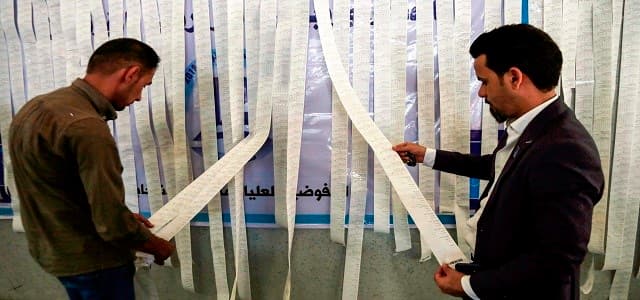 Iraqi electoral commission employees examine electronic counting machine print-outs in the central holy city of Najaf on May 13, 2018. Photo: Haidar Hamdani / AFP
