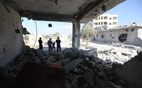Syrians inspect the damaged of buildings on June 11, 2018 following reported air strikes by pro-government forces in the town of Binnish in Syria's northwestern Idlib province. Photo: Omar Haj Kadour / AFP
