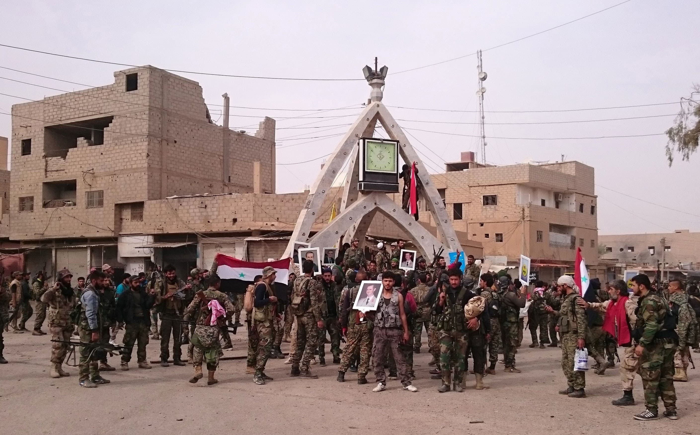 Pro-Syrian government forces celebrate taking control of al-Boukamal, eastern Syria from ISIS last November. Photo: AFP