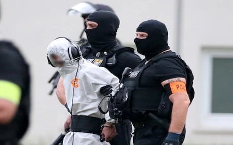 Police officers of a special unit escort Iraqi asylum seeker Ali Bashar, who is suspected of having killed a German teenage girl, to a helicopter in Wiesbaden, western Germany, on June 10, 2018, heading to a prison after Bashar testified. Photo: AFP/ Hasan Bratic