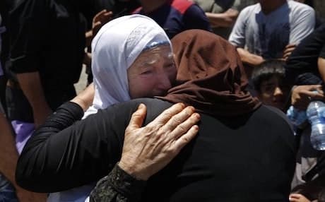 Syrian refugees prepare to cross into Syria by bus at the Lebanese border crossing point of Masnaa, in Bekaa Valley, Lebanon, Saturday, July 28, 2018. About a thousand Syrian refugees are expected to make the crossing on Saturday, after having requested permission from the Lebanese and Syrian governments. Photo: AP/Bilal Hussein.