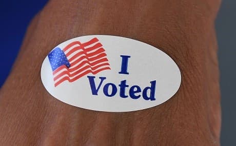 A woman shows an 'I Voted' sticker at an Orange County polling station during the mid-term elections in Huntington Beach, California, November 6, 2018. Photo: Mark Ralston / AFP