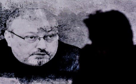 A man passes in front of a screen showing Jamal Kashoggi during a commemoration event of Khashoggi's supporters on November 11, 2018 in Istanbul. Photo: Ozan Kose | AFP