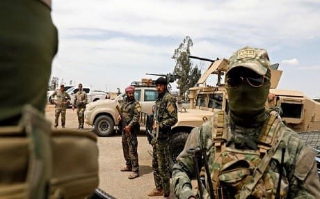 Syrian Democratic Forces and US soldiers, far left, gather prior to launching a renewed military campaign against ISIS in Deir ez-Zor province, Syria, in May 2018. Photo: Delil souleiman/AFP/File