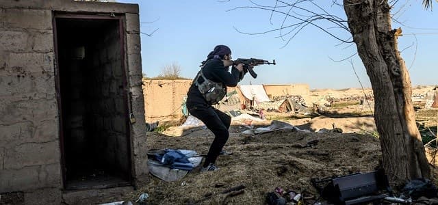 A member of the SDF takes aim with his Kalashnikov assault rifle after seeing a man walking towards his position in the town of Baghouz on March 9, 2019. Photo: Bulent Kilic/AFP
