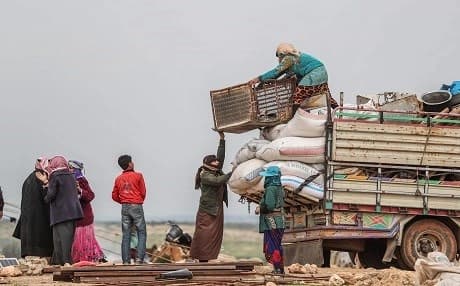 Displaced Syrians prepare to flee after their makeshift camp was destroyed following reported air strikes on the outskirts of the jihadist-held city of Idlib on March 13, 2019. Photo: Omar Haj Kadour/AFP