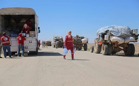 Teams from the Syrian Arab Red Crescent bring water to displaced persons as a convoy led by the Syrian Arab Army transports displaced persons from al-Rukban, Jordan, to Homs, Syria in this photo posted on April 12, 2019. Photo: SARC